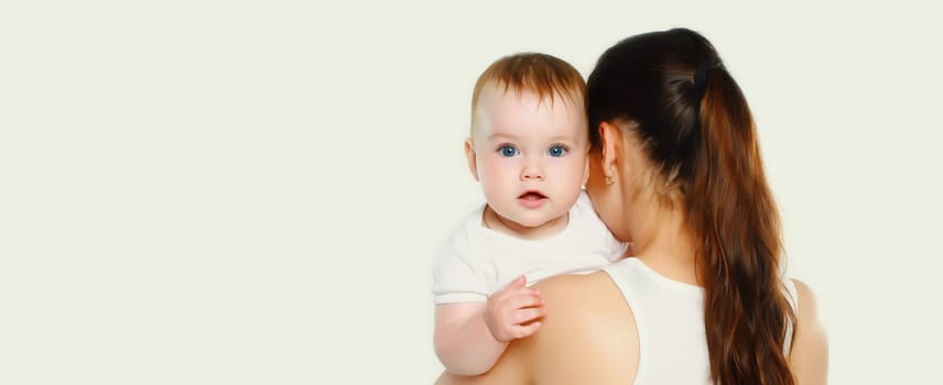 Portrait of happy young mother holding baby on white studio background