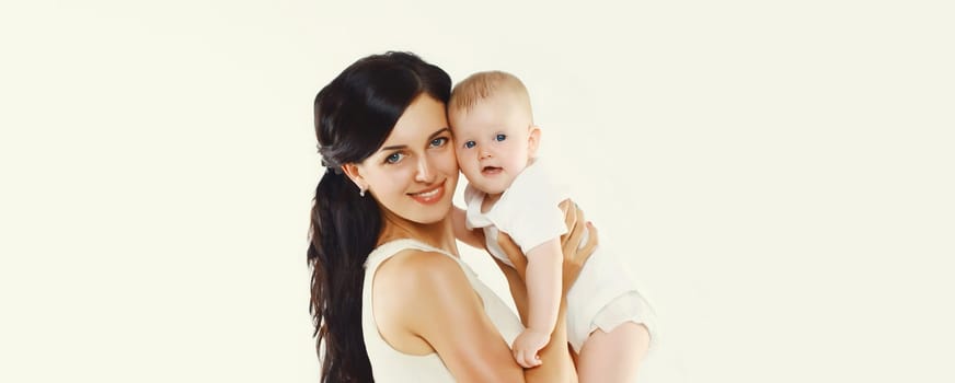 Portrait of happy young mother holding baby on white studio background