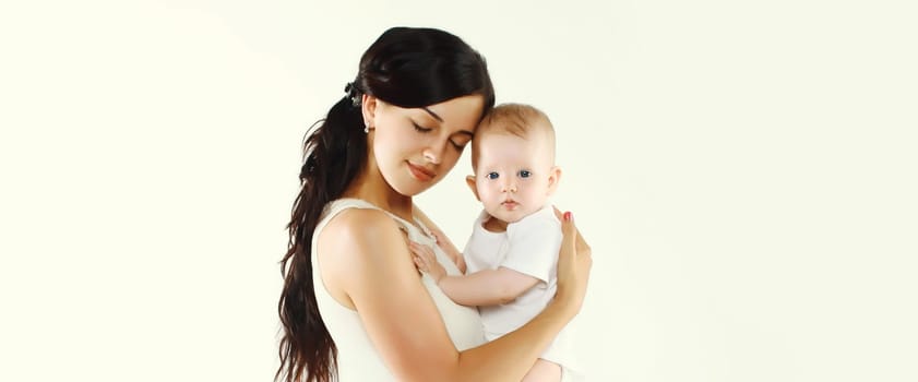 Portrait of happy young mother holding baby on white studio background