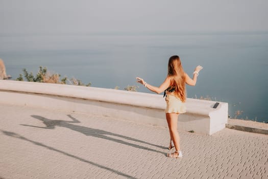 silhouette of a happy woman who dances, spins and raises her hands to the sky. A woman is enjoying a beautiful summer day.