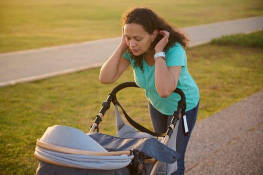 Young woman on maternity leave taking her baby out in a stroller. Mother with baby pram outdoors. Copy space