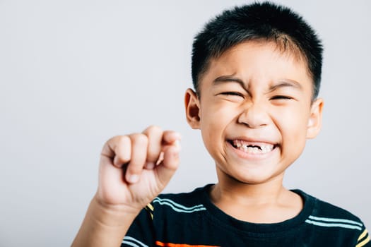 Child holds fallen baby tooth indicating good dental care. First tooth loss represents toddler growth joy and happiness. Children show teeth new gap, dentist problems