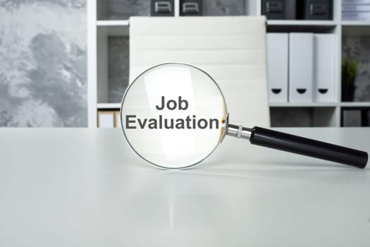 Job evaluation concept. Office workplace and magnifying glass.