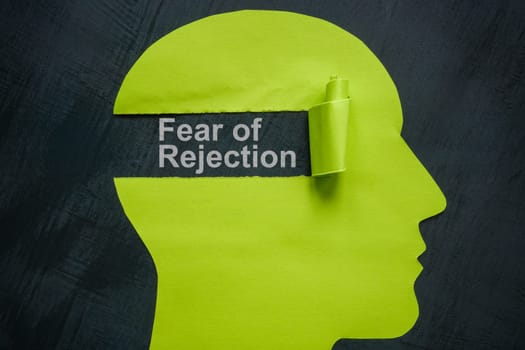 Fear of rejection concept. Green paper head and torn off piece.