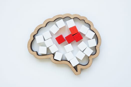 Brain model and red cubes as concept of disease or pain in the head.