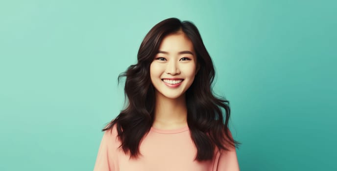 Portrait of beautiful happy smiling asian young woman with toothy smile looking at camera on green studio background