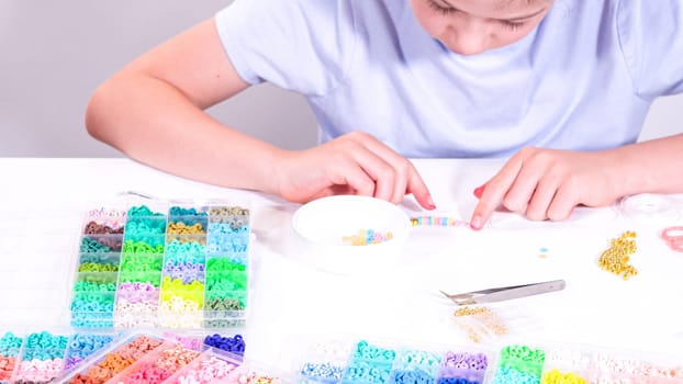 Delicate fingers of a young girl navigate through a treasure trove of bright, multicolored beads, each compartment revealing a new hue to choose from.