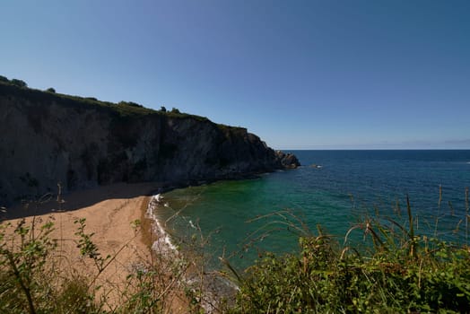 Beach of Liencres, Costa Quebrada, on a sunny day. geological formations, cliffs, no people, lines, cloudless sky