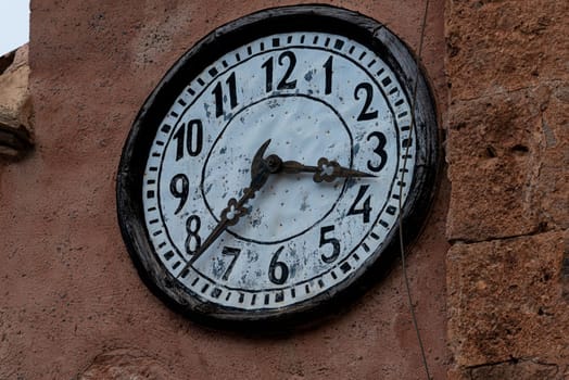 Antique Church Clock: Stone Facade Timepiece.An antique clock adorns the stone facade of a historic church, its traditional clock hands marking the passage of time with timeless elegance