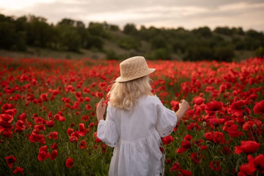 A young girl wearing a straw hat is walking through a field of red poppies. The scene is serene and peaceful, with the girl enjoying the beauty of the flowers