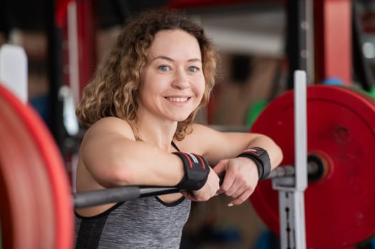 Middle aged woman resting after deadlifting in the gym