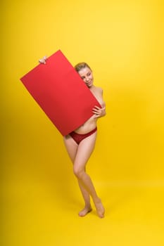 Blonde model, Young woman holding a cardboard cloud red sheet of papaer, place for an inscription