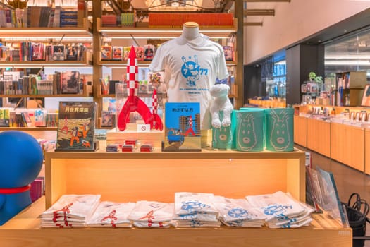 tokyo, ginza - may 17 2024: Japanese bookstore display with comics, t-shirts, merchandises like rocket model from french bande dessinée The Adventures of Tintin created by Belgian cartoonist Hergé.