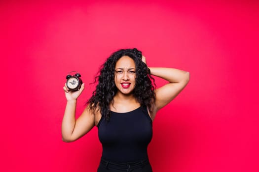 Shocked young woman holding alarm clock, emotional african american female student late to study