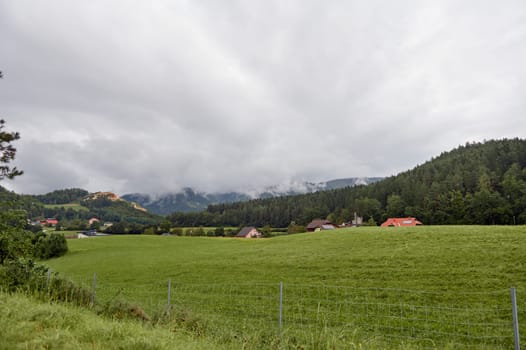 View to valley with beautiful cottages and chalets in the Carpathians mountains ridge on a foggy day. Slovakia. Countryside. Nature landscape. Rural scene