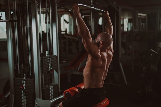 Caucasian man doing lat pull-downs on a machine