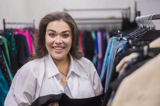 Smiling fat woman in plus size store looking at camera