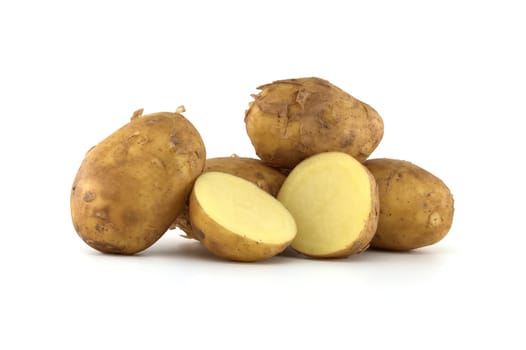 Early season potatoes with a light brown skin isolated on a white background, one potato bisected displaying its yellow interior