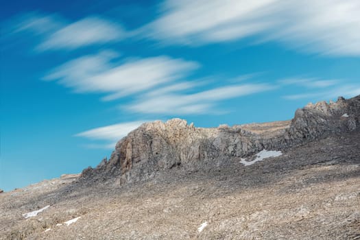 Rocky hill with clouds visible in the background on a sunny day