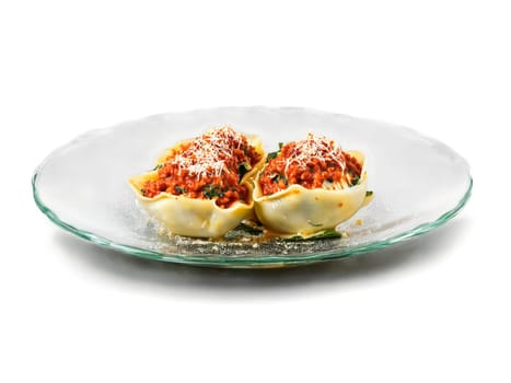 Vegetarian spinach and ricotta stuffed shells with tomato sauce served on a transparent glass dish. Food isolated on transparent background.