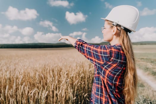 Woman farmer walks through a wheat field at sunset, touching green ears of wheat with his hands. Hand farmer is touching ears of wheat on field in sun, inspecting her harvest. Agricultural business.