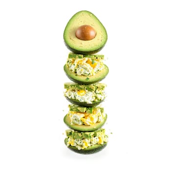 Avocado egg salad creamy and tangy tumbling and mixing with bits of egg and herbs. Food isolated on transparent background.