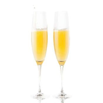 Mimosa glass tall champagne flute one empty and one filled with orange juice and champagne. Food isolated on transparent background.