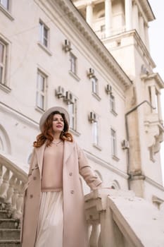 woman in elegant coat and hat against an intricate architectural backdrop, harmoniously blending modern fashion with historical allure. The soft daylight adds to its timeless appeal