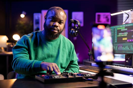 Audio technician teaching people to operate a mixing console during online master class, recording a video with important post production explanations. Producer hosting music editing lessons.