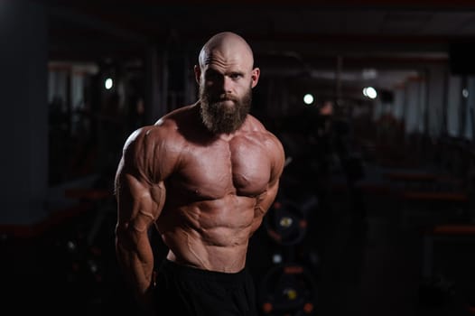 Caucasian bald man posing in the gym