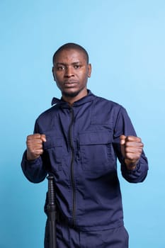 African american bodyguard feels confident with his fighting skills, posing with clenched fists and ready to protect and safeguard. Male agent defending the premises, taking combat safety measures.