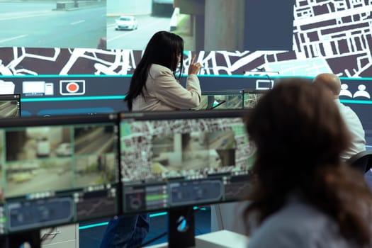 Indian team leader instructs her staff to help couriers on field with gps coordinates of the shipment location, offering information on city routes by satellite map navigation. Order tracking.