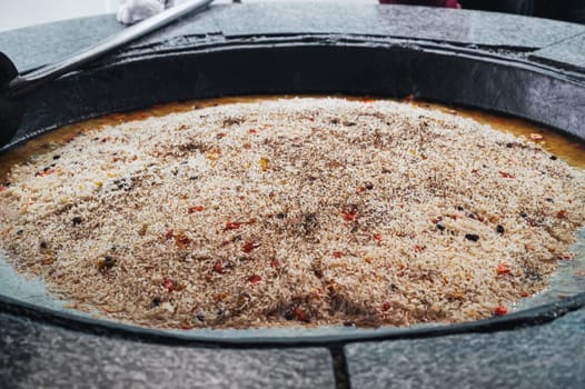 dish of Uzbek cuisine is rice pilaf in big cauldron in the kitchen of an Asian restaurant in Tashkent Pilaf Center Besh Qozon in Uzbekistan