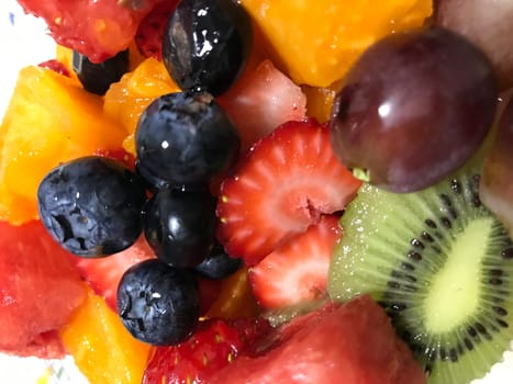 Vibrant close-up shot of a fresh mixed fruit salad with various berries and slices