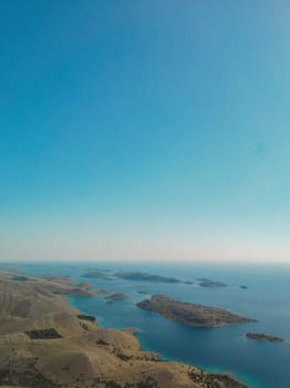 Drone aerial view of Kornati archipelago in Croatia, small empty islands and blue water to horizon