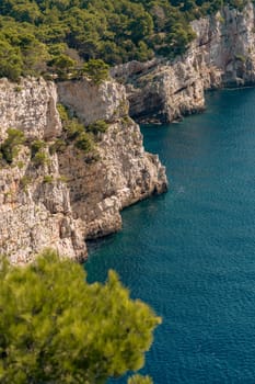 Aerial view of spectacular cliffs with green trees above blue sea shore, Dugi Otok island, National Park Telascica, Croatia