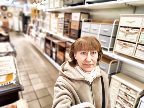 Girl while shopping in a store. A middle-aged woman chooses shopping on the trading floor