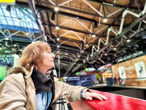 Middle-Aged Woman Taking Selfie at Airport Before Departure. A middle-aged woman captures selfie in an airy airport terminal