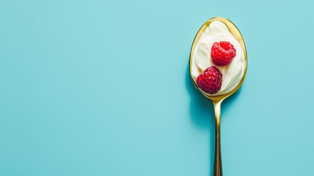 Golden spoon filled with creamy yoghurt and topped with fresh raspberries