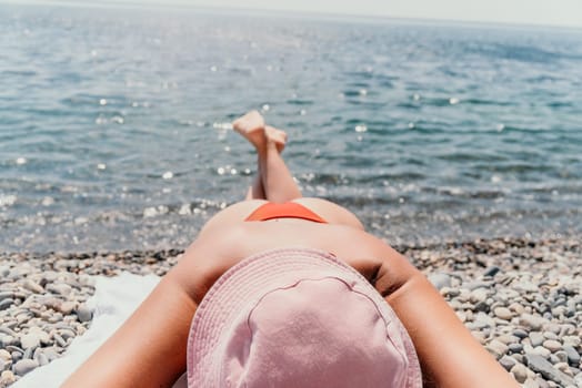 Happy smiling young woman sunbathing or tanning on a seaside beach during summer vacation. Slow motion of happy tourist in red swimsuit enjoying sun tan lying on beach chair lounge at luxury resort.