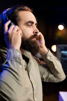 Computer engineer listening music while updating artificial intelligence neural networks, writing binary code script. IT professional enjoying music and upgrading high tech AI in home office