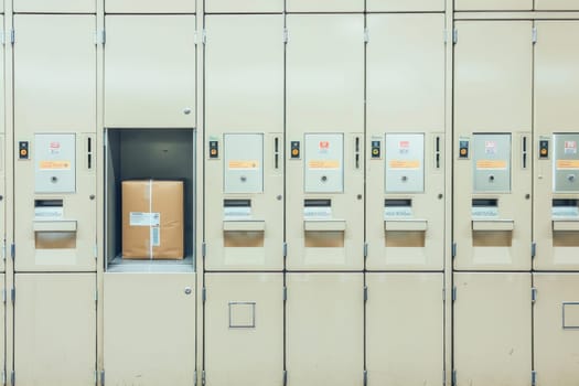 A box sits within a locker in a line of lockers, underlining concepts like rectangle, cabinetry, metal, and door