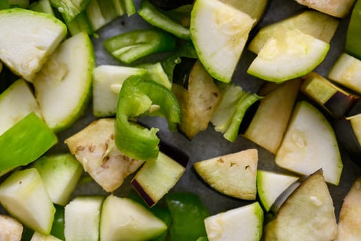 Eggplant, zucchini and peppers cut into diced and placed on a baking tray