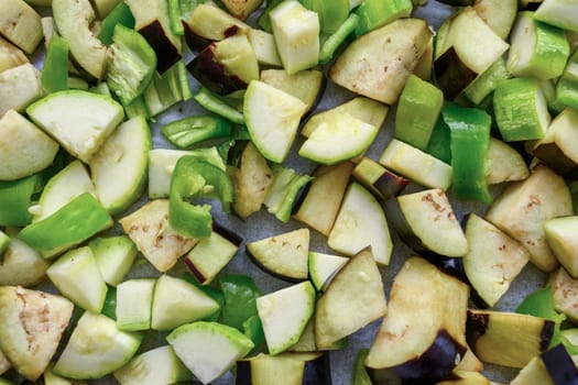 Eggplant, zucchini and peppers cut into diced and placed on a baking tray