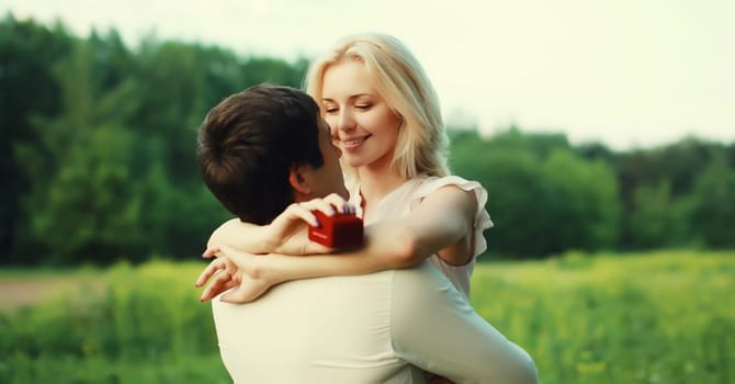 Wedding concept, happy lovely young couple, man proposing a ring to his beloved woman outdoors in summer park