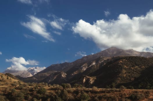 landscape with mountain peaks background the sky with clouds at sunset in a summer