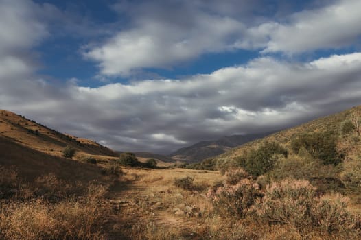 autumn valley with mountain view with cloudy sky at sunset
