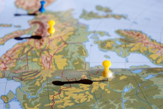 Yellow and blue pushpin showing the location of a destination point on a map. travel concept
