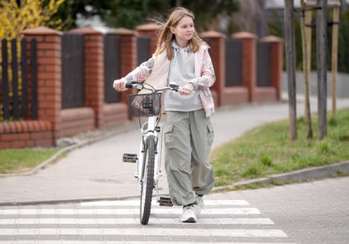 Girl Crosses Road On Pedestrian Crossing With Bicycle In Spring