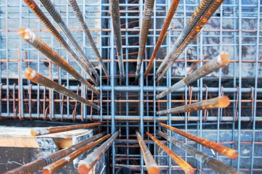 Embedded frame for a column made of steel reinforcement protrudes from the main reinforcement frame of the floor on a construction site.